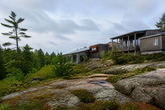 Modern research buildings beside a forested Canadian Shield landscape
